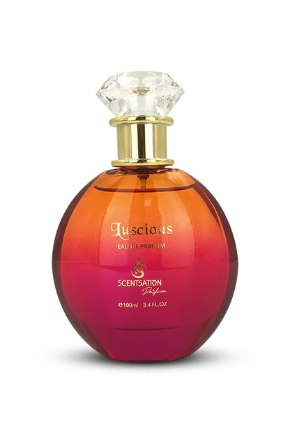 A bottle of SCENTSATION LUSCIOUS EAU DE PARFUM with a clear, faceted golden cap on a gradient background that transitions from red to orange.